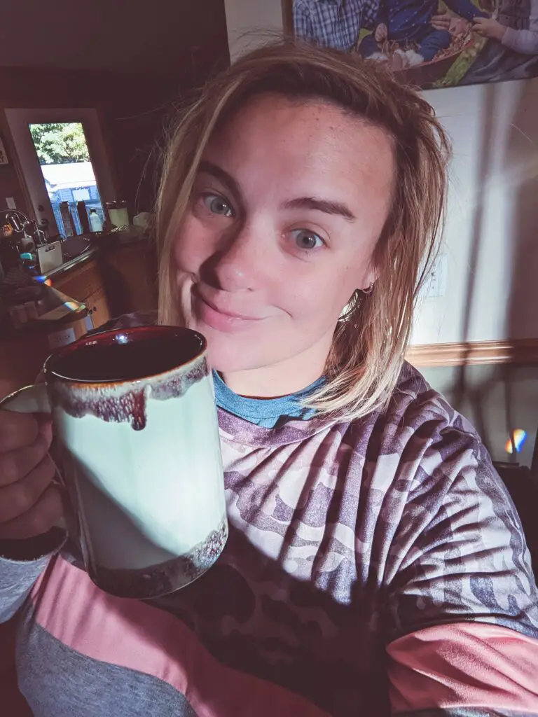 woman holding coffee mug and taking selfie